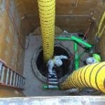 Installing a flow-through plug for a manhole abandonment